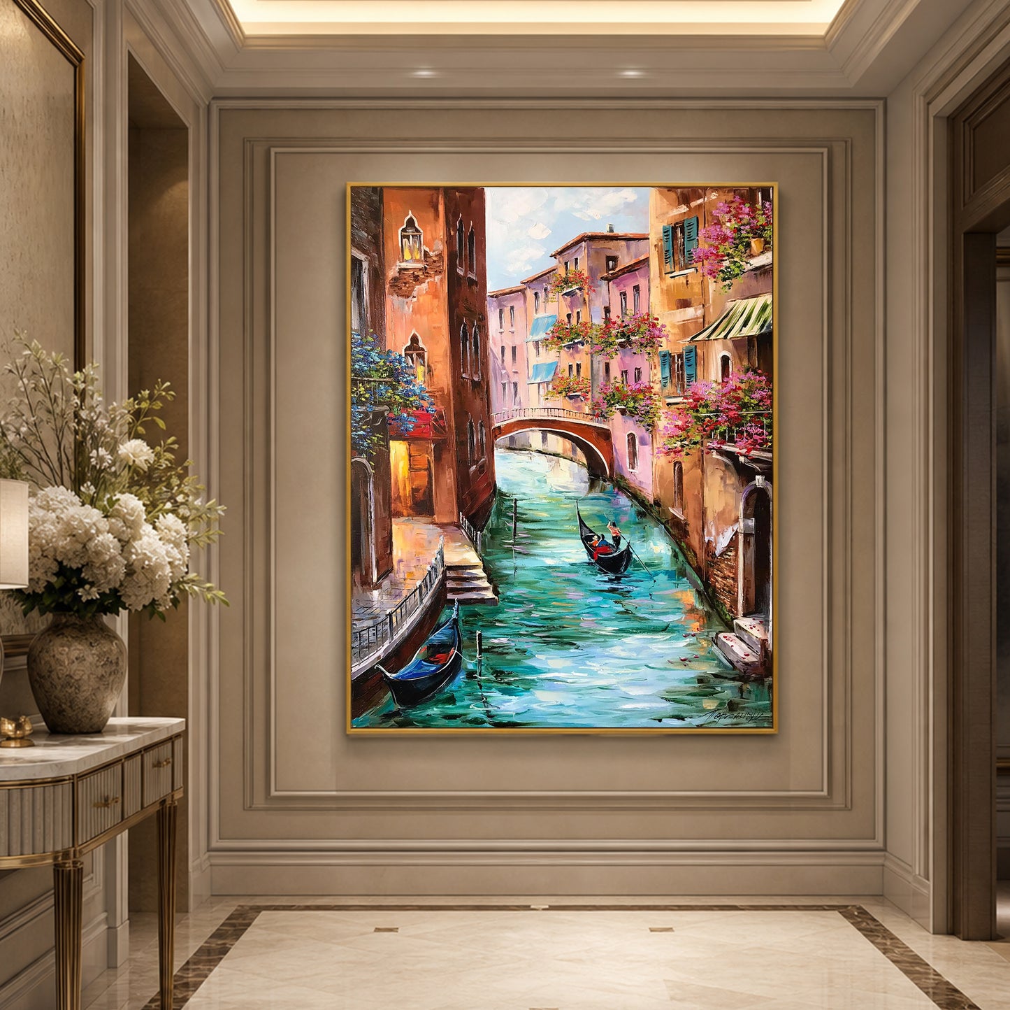 A framed canvas painting of a Venetian canal scene with gondolas, colorful buildings, and a bridge, displayed on a beige wall in an elegant interior hallway.