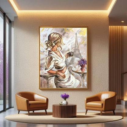 A framed oil painting depicting a woman in a white dress with the Eiffel Tower in the background, displayed on a wall in a modern living room setting with two brown leather armchairs and a small wooden coffee table.