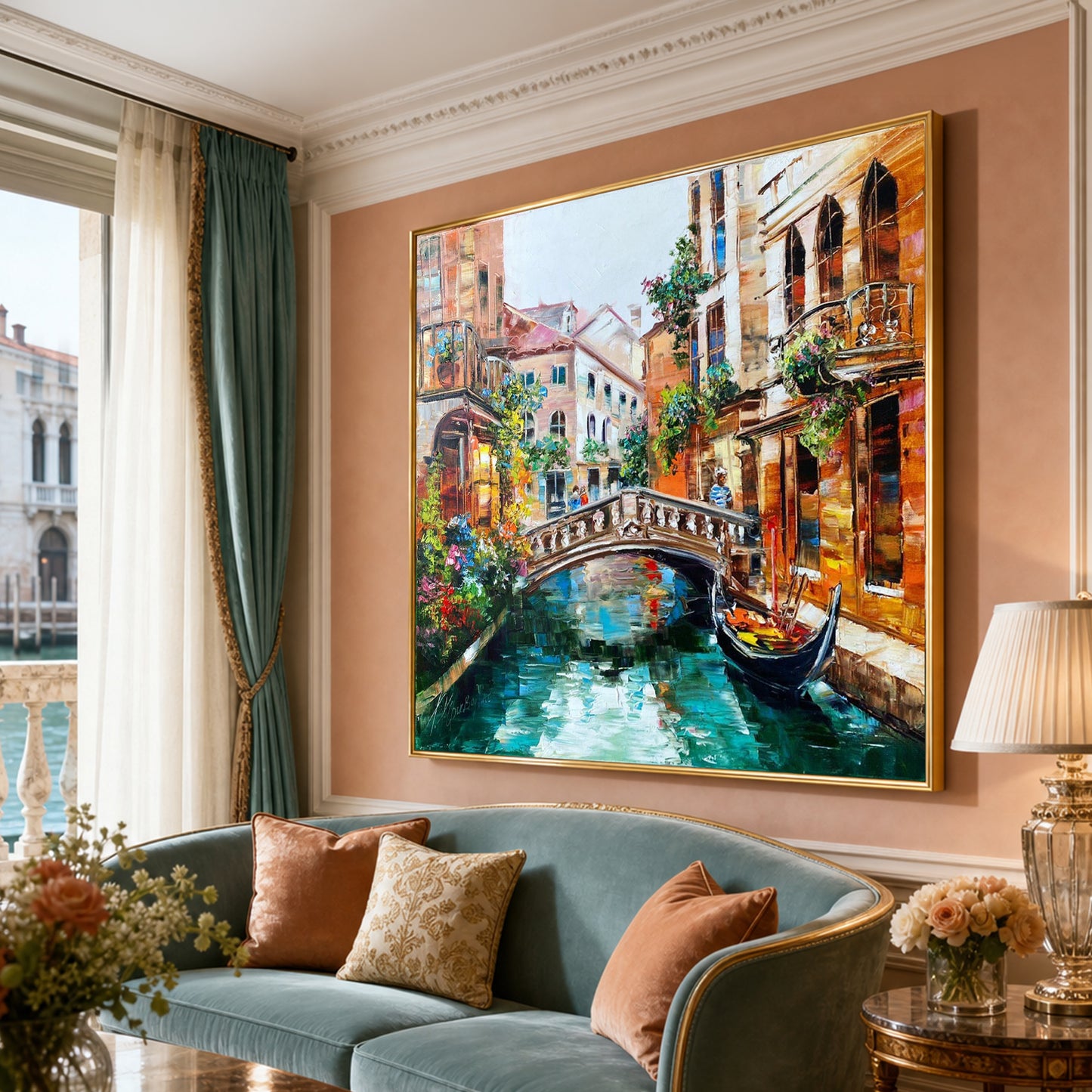A large framed canvas painting of a Venice canal scene with a bridge and gondola, displayed on a peach wall above a blue-green sofa in a styled living room.