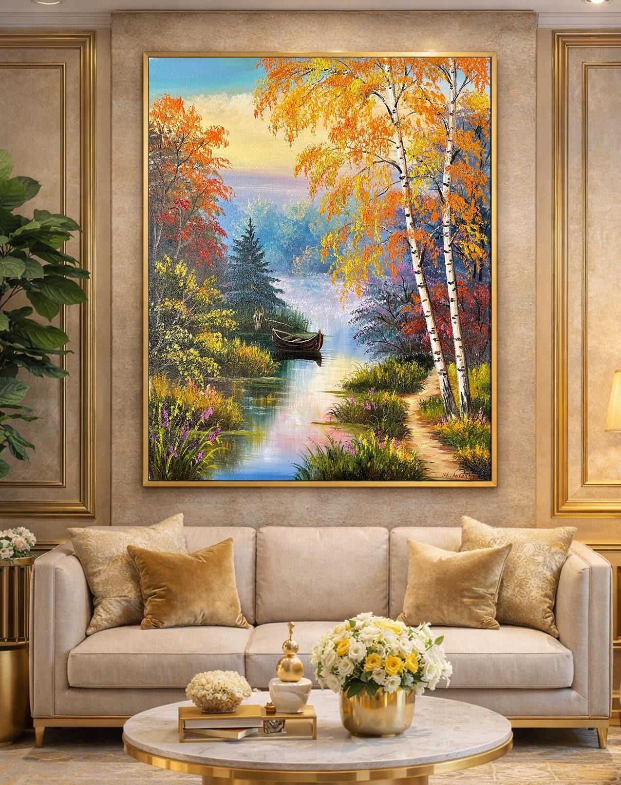 Framed painting of a scenic landscape with trees and a lake in a living room.