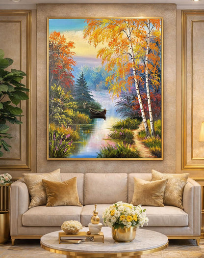 Framed painting of a scenic landscape with trees and a lake in a living room.